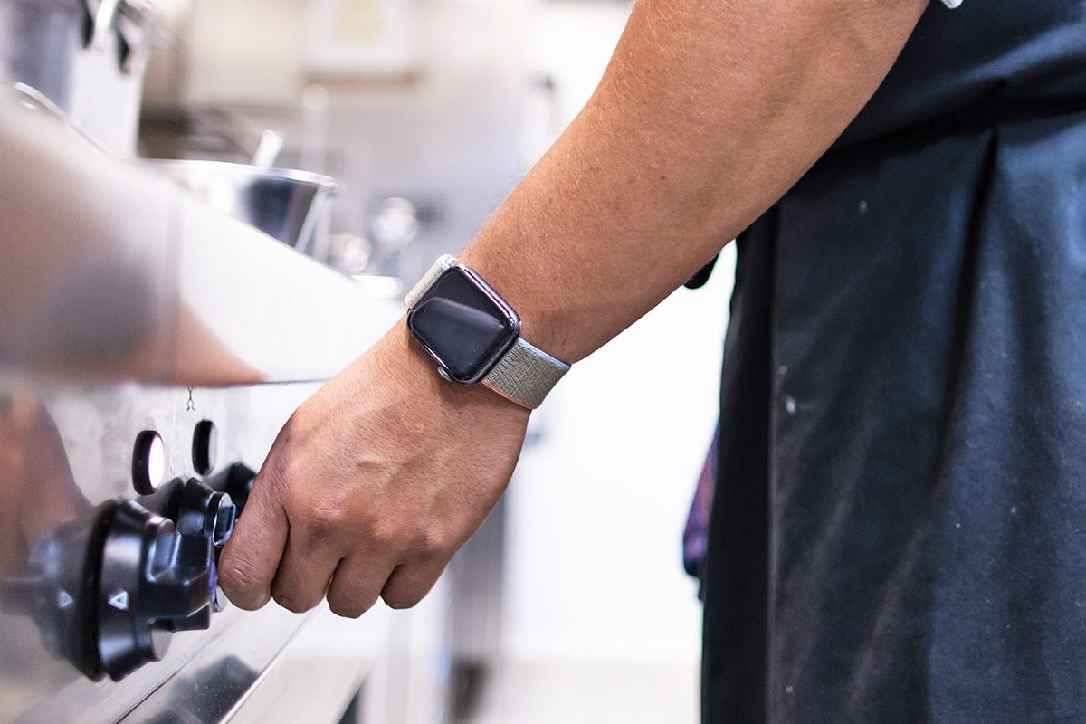 Hand with smart watch in a kitchen lighting the stove
