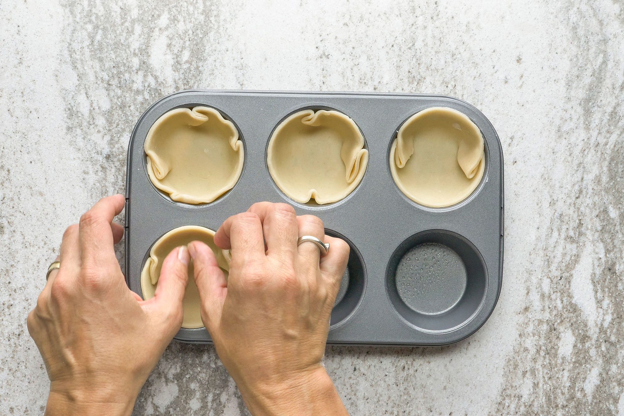 Press circles onto bottoms and up sides of 6 greased muffin cups