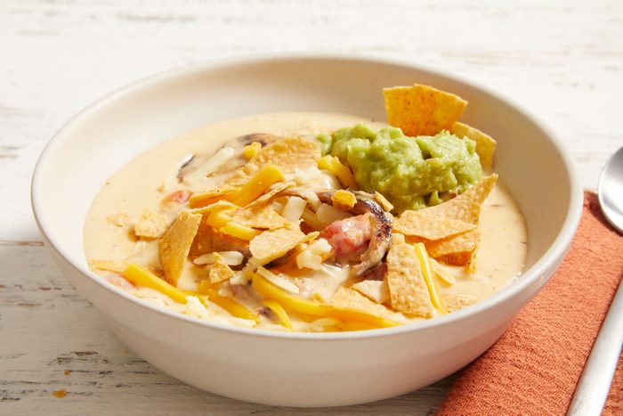 3/4 shot of Cheesy Tortilla Soup served with Guacamole and tortilla chips