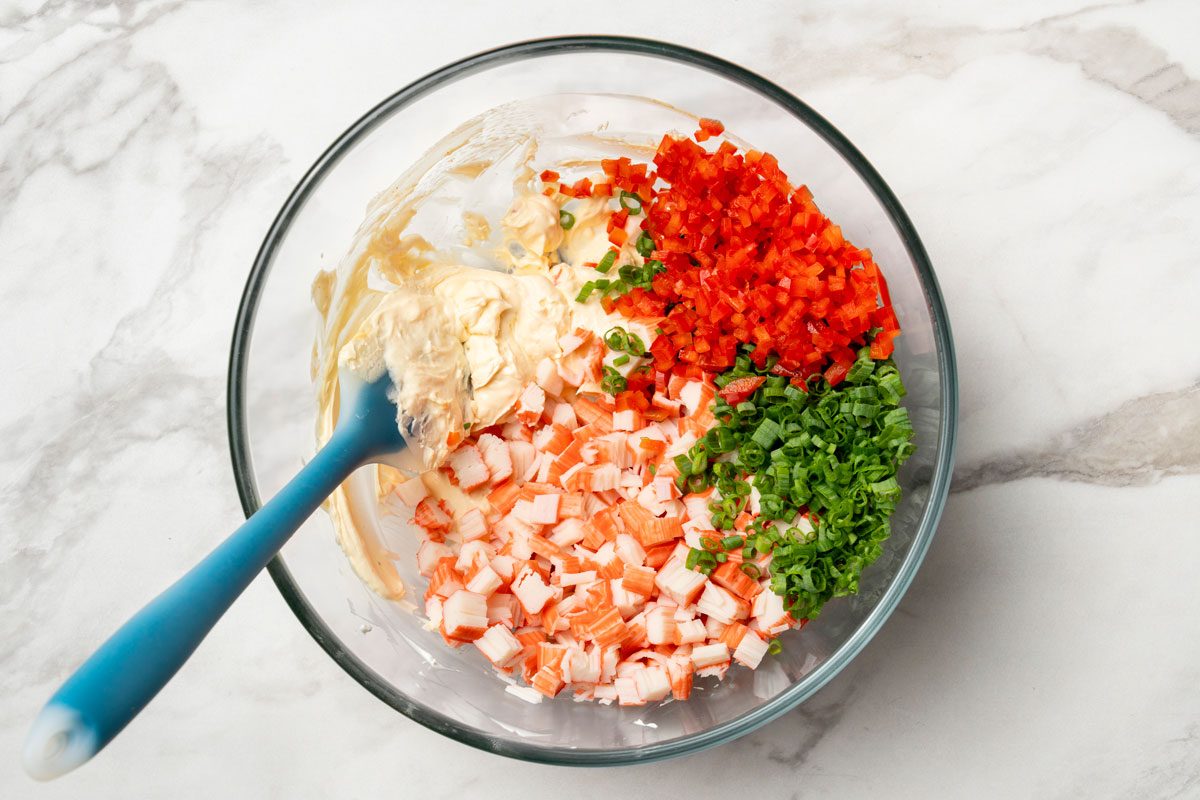 Fold in the crab, red pepper and onions. mix with spatula