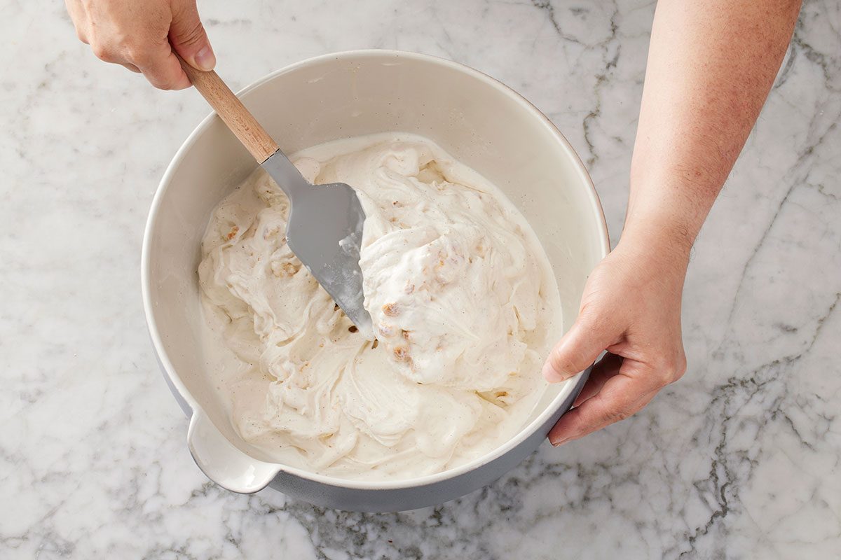 Toaseted marshmallows being spoon foldeed in to the ice cream mixture