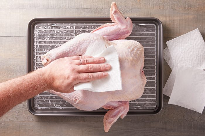 patting turkey dry with paper towels
