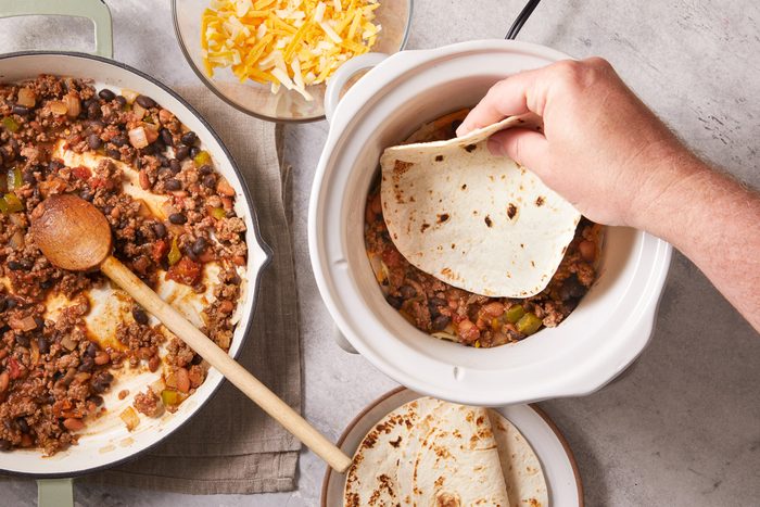 placing tortilla over beef mixture