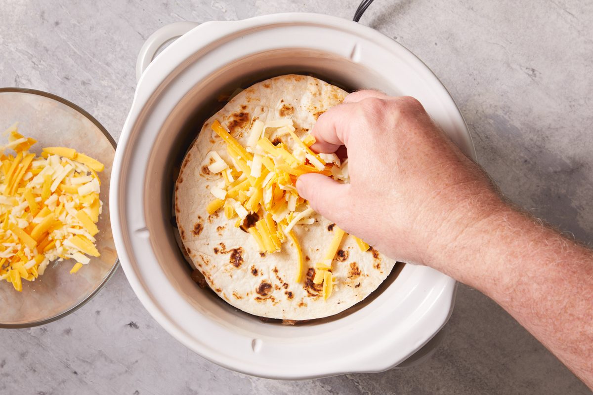 adding cheese on top of tortilla