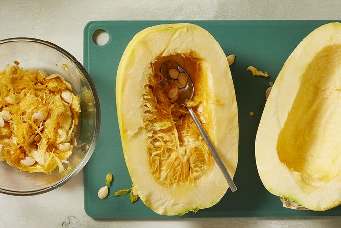 Scooping the seeds and stringy bits from a squash