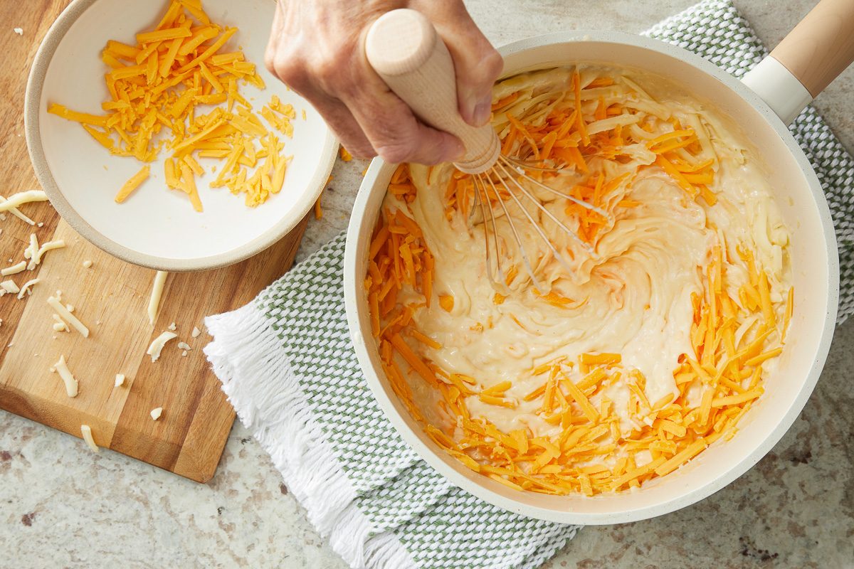 cheese being mixed in with onion and cream mixture
