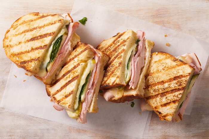 Grilled cuban panini dish of four pieces on a counter.