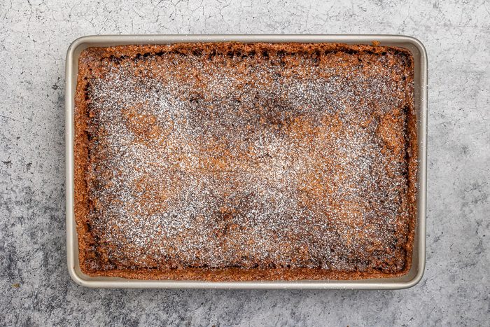 baked batter in a pan dusted with confectioners' sugar