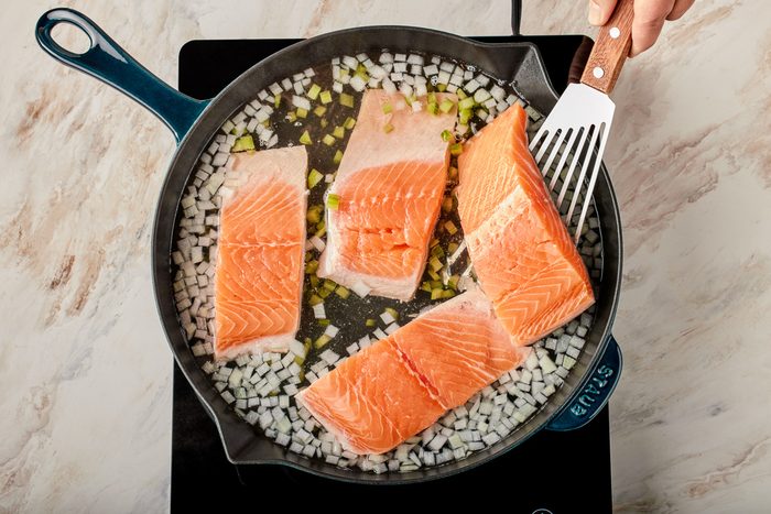 salmon being cooked in a skillet