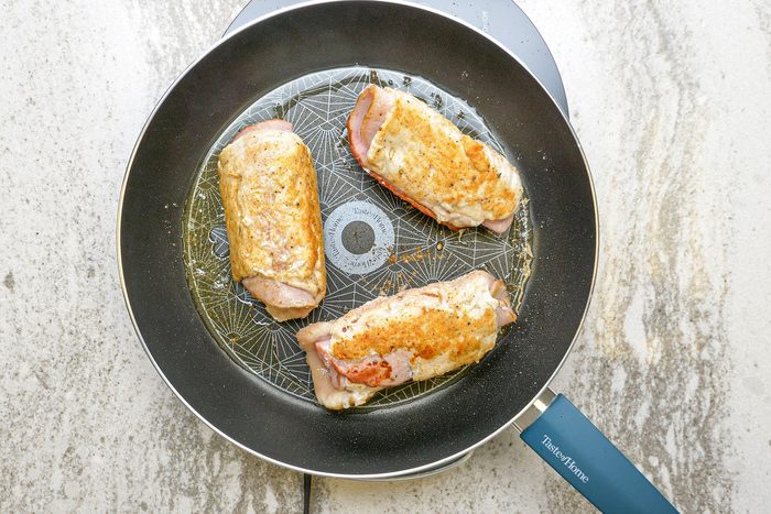 Add the chicken rolls to heated canola oil in a large skillet and cook until they are brown on all sides.