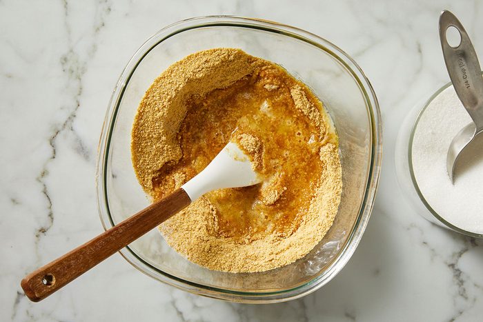 In a bowl, combine the graham cracker crumbs, butter and sugar.