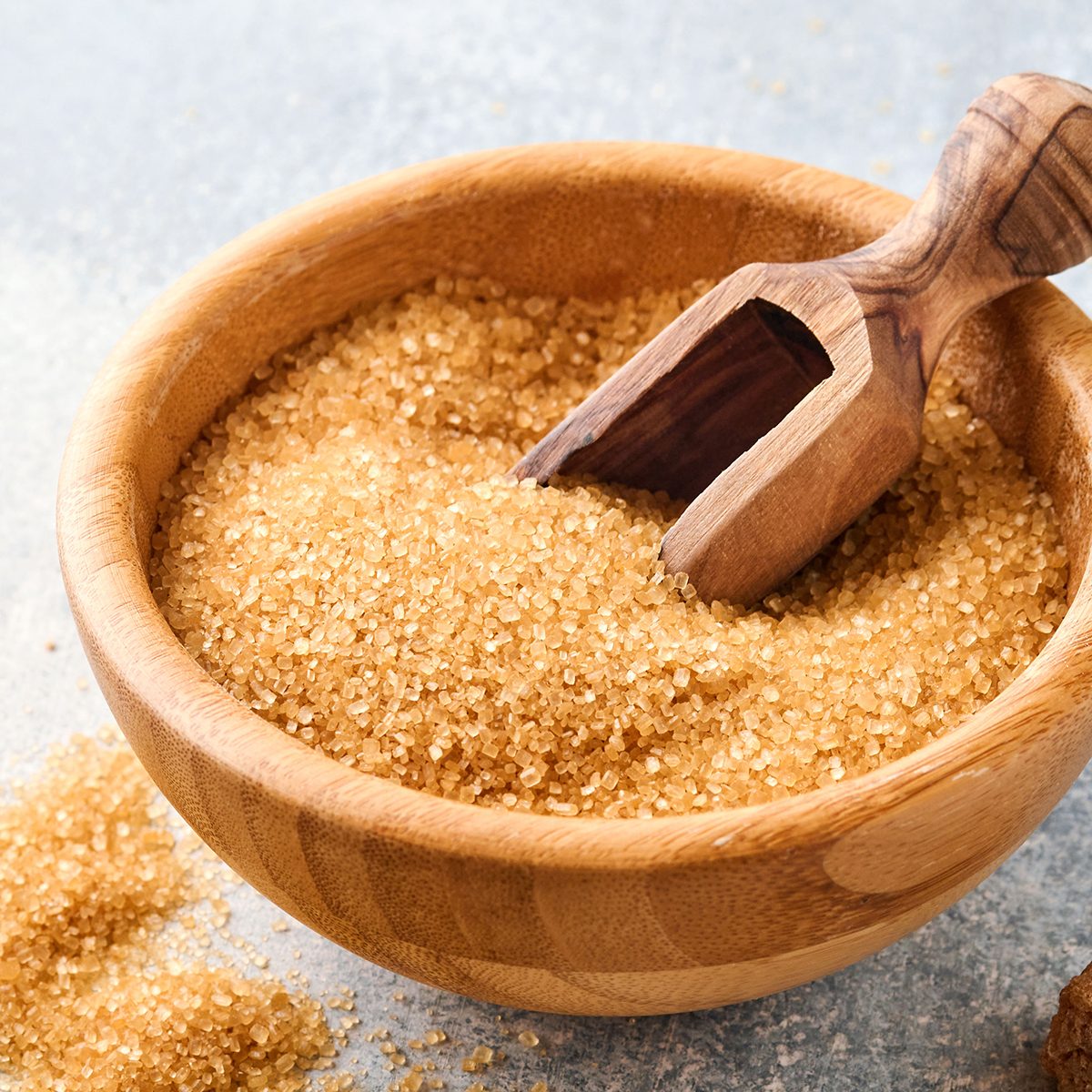 Cane sugar cube in bamboo bowl on gray table concrete background