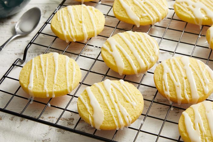 Close-up of glazed Lemon Slice Sugar Cookies arranged on a cooling rack, showing detailed texture and lemon drizzle.