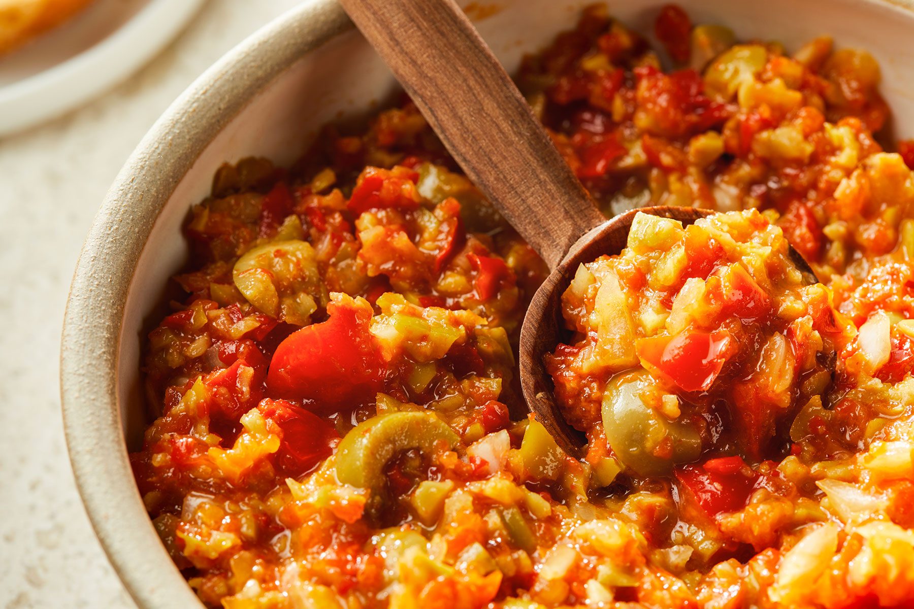 Close up shot of Olive Relish with a serving spoon in a bowl.