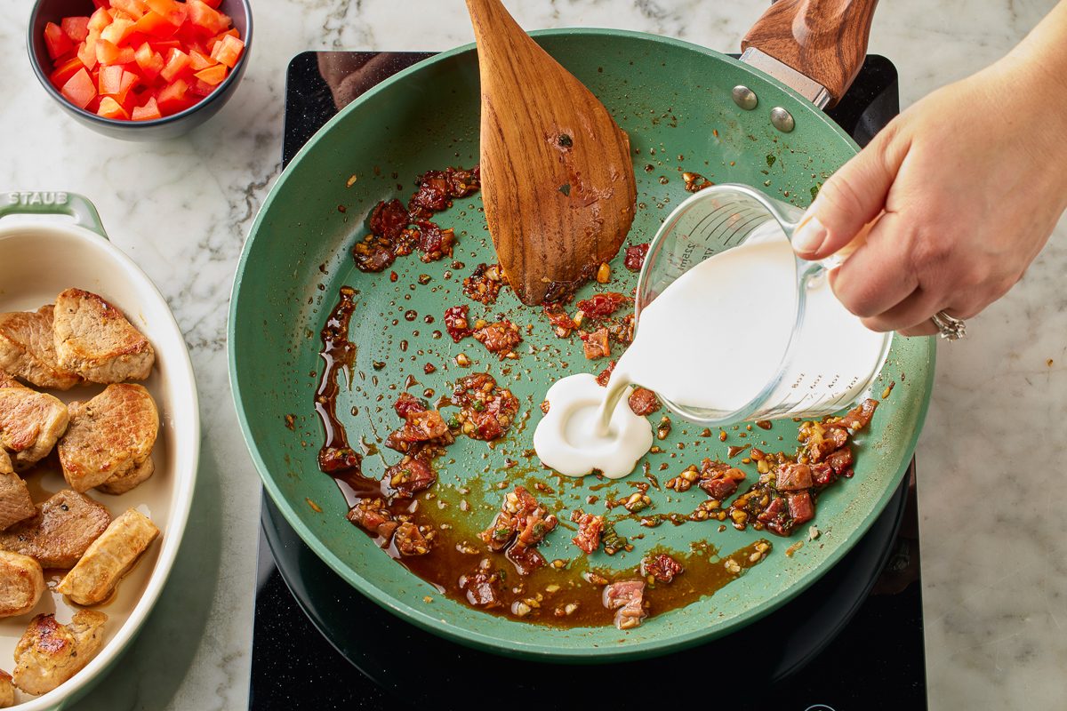 heavy cream being added to pan