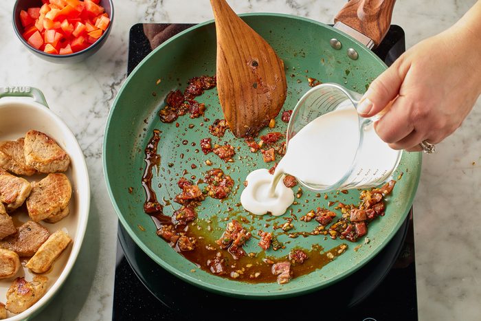 heavy cream being added to pan