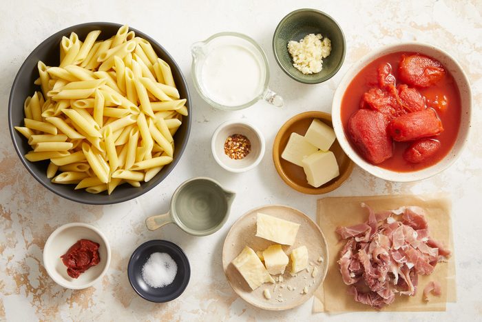 butter, garlic cloves, prosciutto, tomato paste, whole plum tomatoes, vodka, salt, pasta, parmesan cheese, whipping cream and red pepper flakes