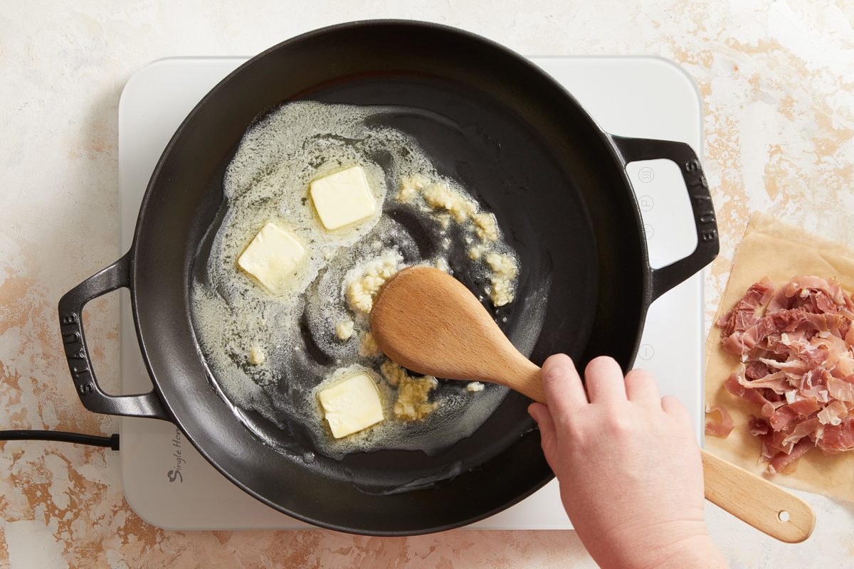 cooking garlic with butter in a large skillet