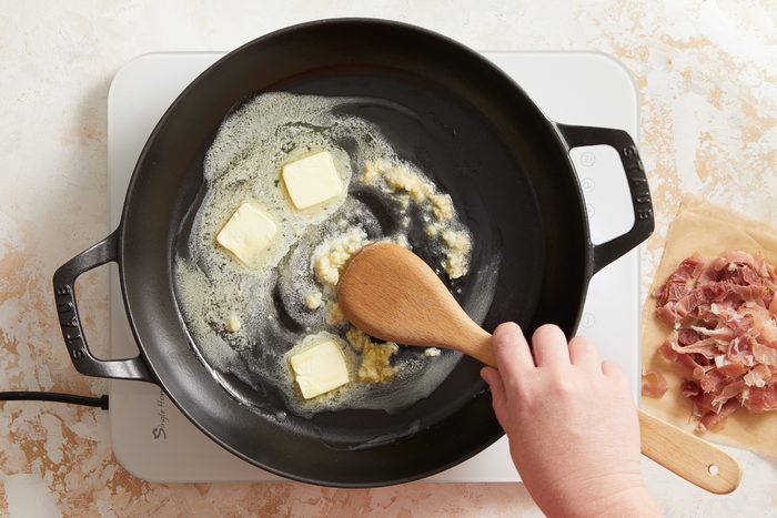 cooking garlic with butter in a large skillet