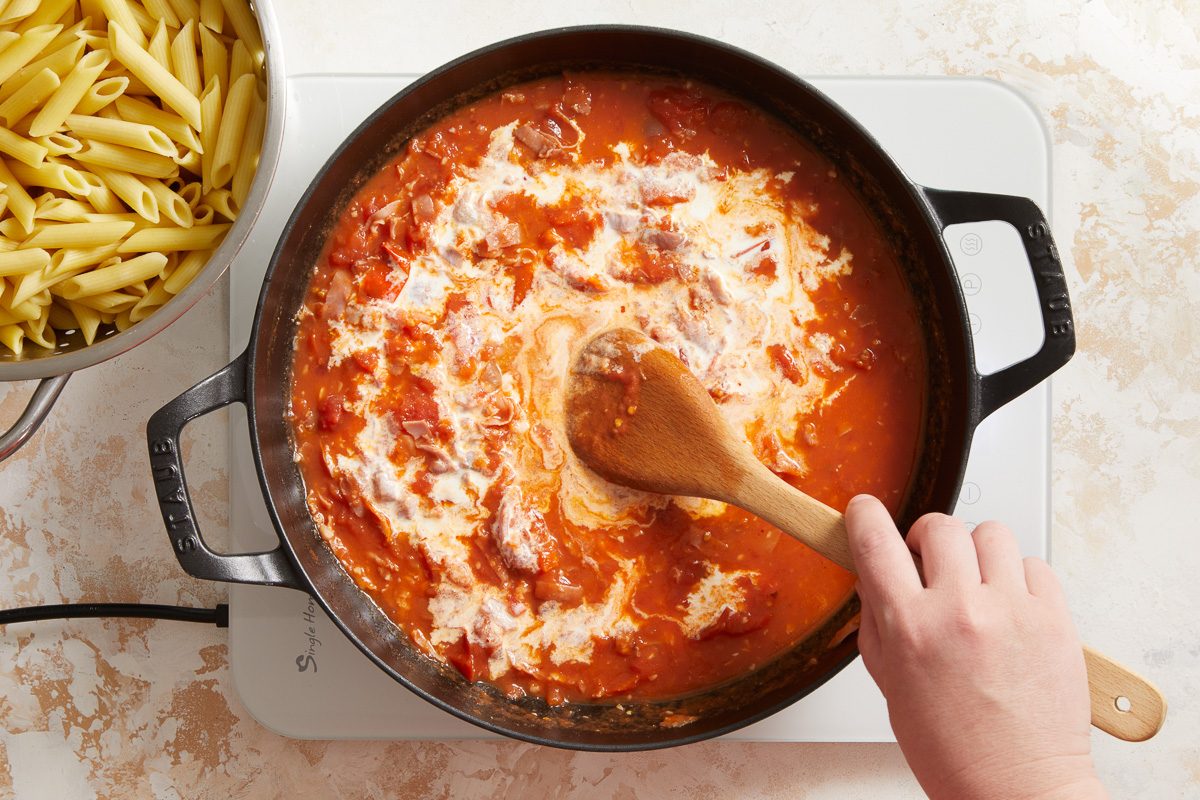 cream added to sauce being cooked in a large skillet