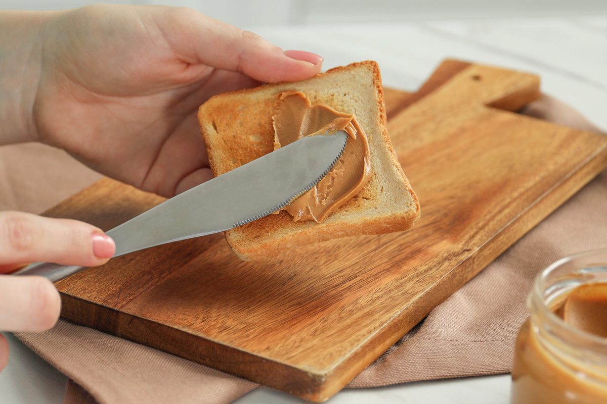 spreading peanut butter on bread