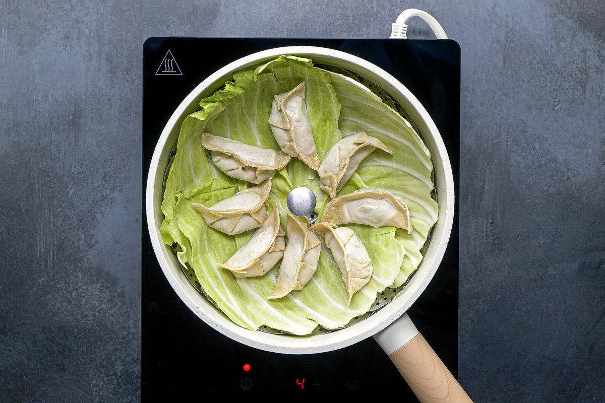 dumplings on cabbage leaves in steamer basket