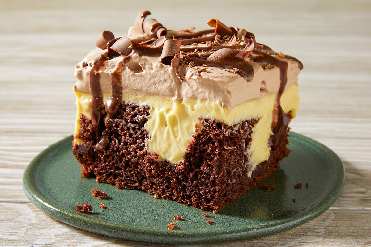 Top-down image of sliced Irish cream poke cake squares arranged in a baking dish, highlighting the layered interior and decorative topping.