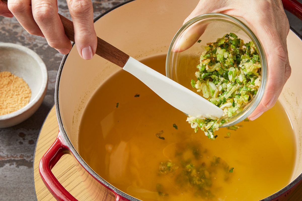 adding sliced green onion, minced ginger and garlic to the dashi