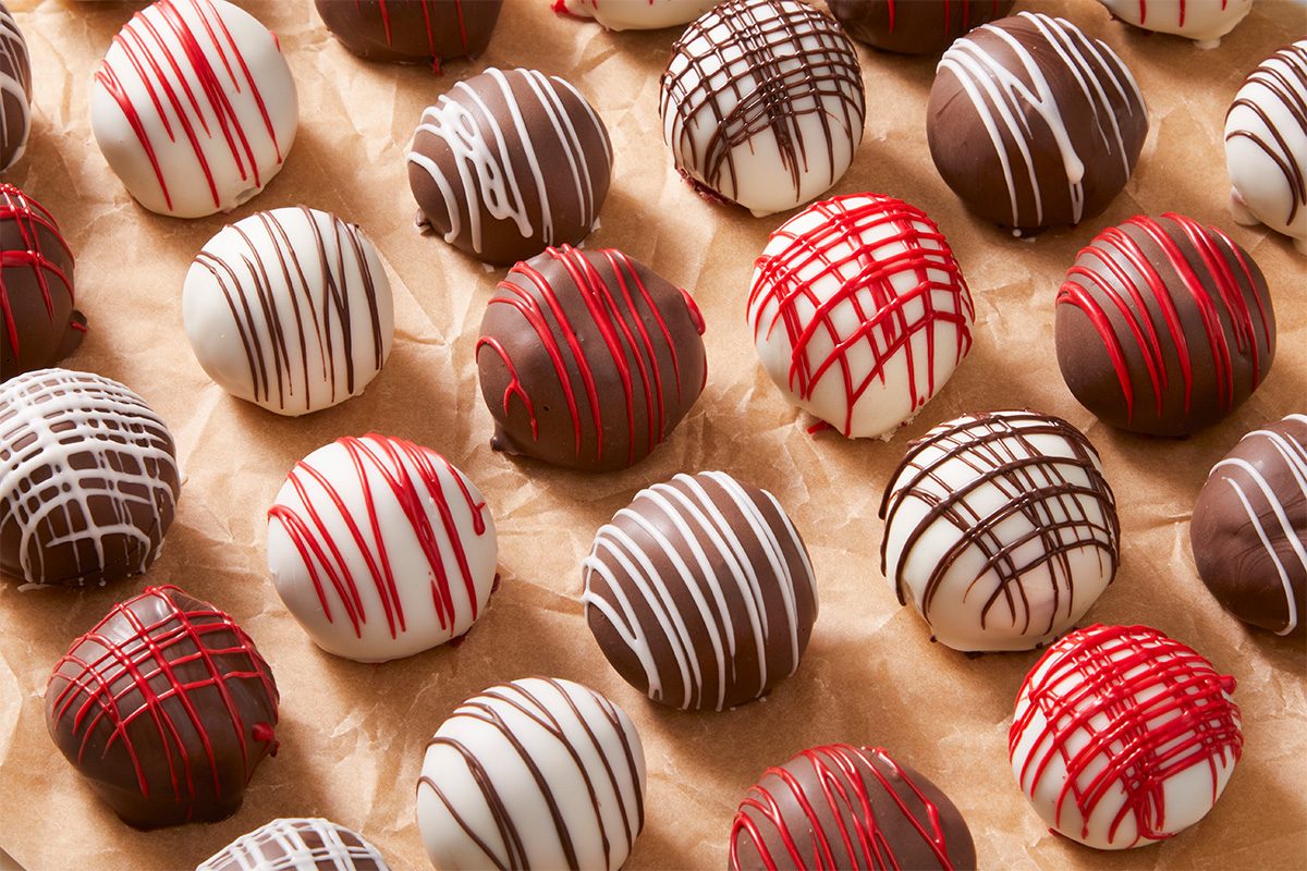 A overhead, horizontal shot of Red Velvet Cake bites on parchement paper.