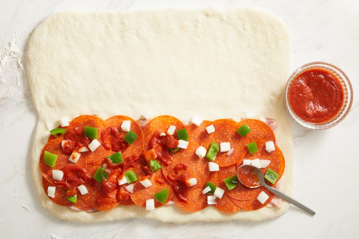 chopped onions and green peppers sprinkled on top of ham and pepperoni